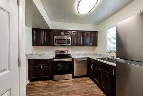 A kitchen with dark brown cabinets and stainless steel appliances.