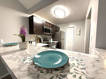 A kitchen with a marble countertop and a blue plate on it.