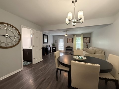 A dining room with a large table and chairs.