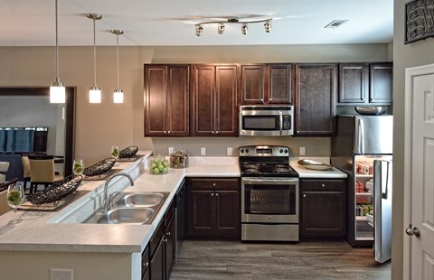 A kitchen with dark brown cabinets and stainless steel appliances.
