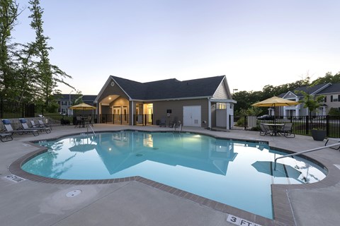 A large swimming pool in front of a house.