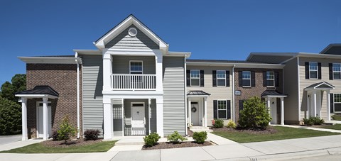 A row of houses with a clear blue sky above them.