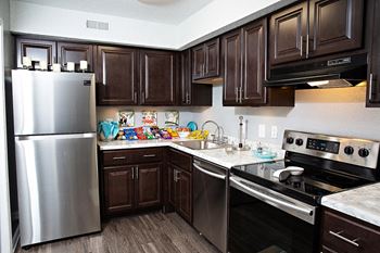 a kitchen with dark cabinets and stainless steel appliances