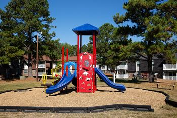 a playground with a blue and red structure and a red and blue slide