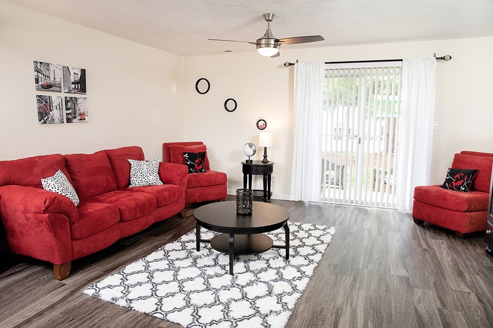 A living room with red couches and a black coffee table.