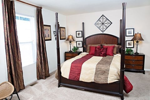 A bedroom with a canopy bed and a chair.
