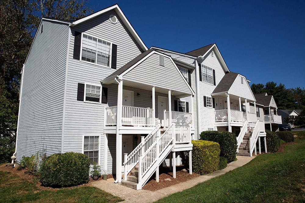 a row of white houses with stairs and balconies