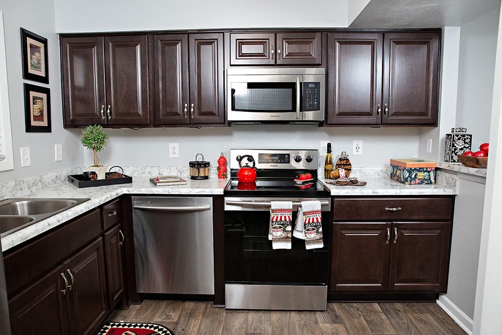a kitchen with stainless steel appliances and dark wood cabinets