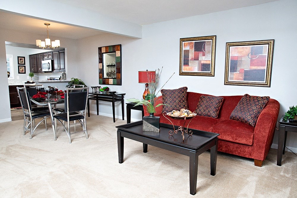 a living room with a red couch and a dining room table