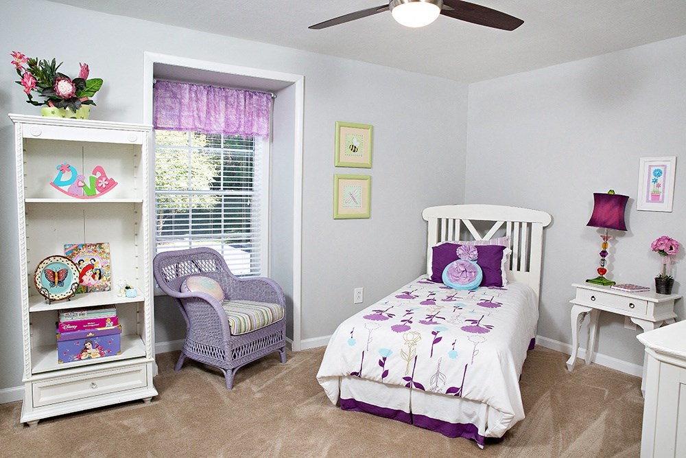 a bedroom with a bed and a dresser and a window