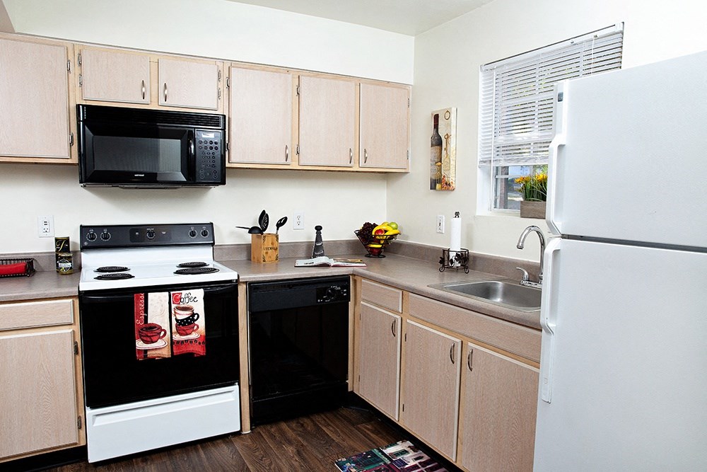 a kitchen with a white refrigerator freezer next to a stove top oven