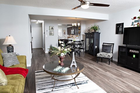 A living room with a glass table and a yellow couch.