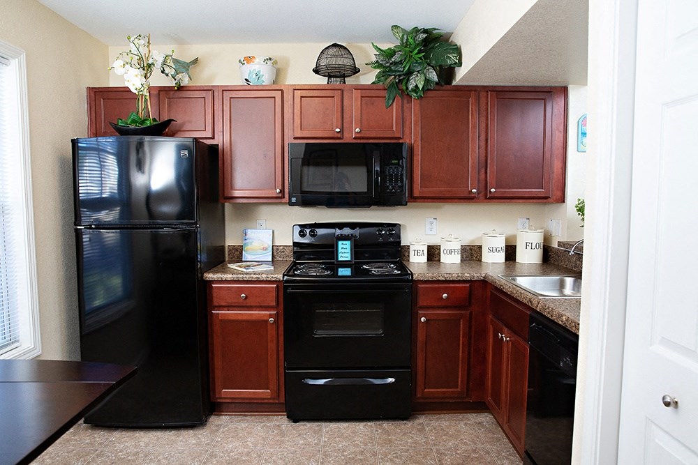 a kitchen with dark wood cabinets and black appliances