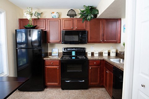a kitchen with black appliances and wooden cabinets