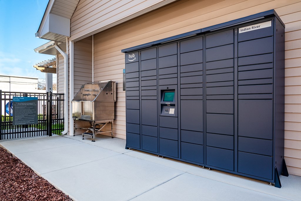 A large blue storage unit with a sign that reads "Indian River" is situated outside a building.