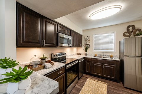 A kitchen with dark brown cabinets and a white counter top.