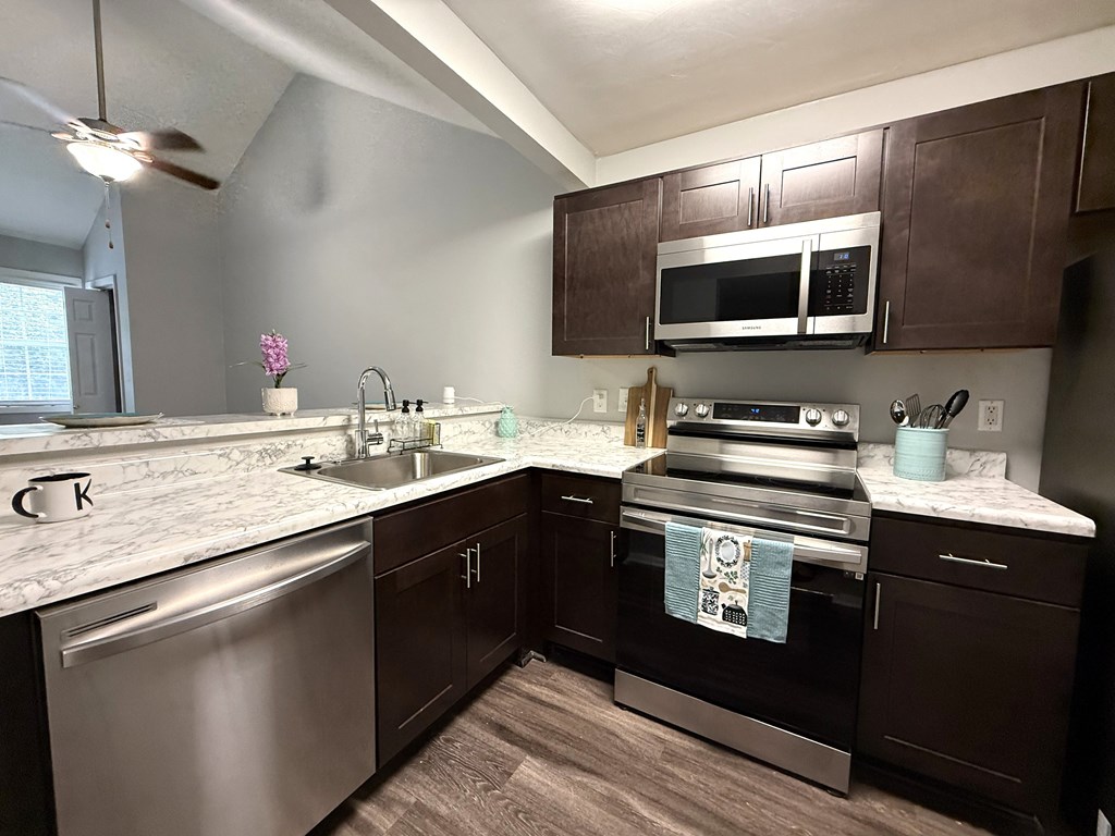 A kitchen with dark brown cabinets and stainless steel appliances.