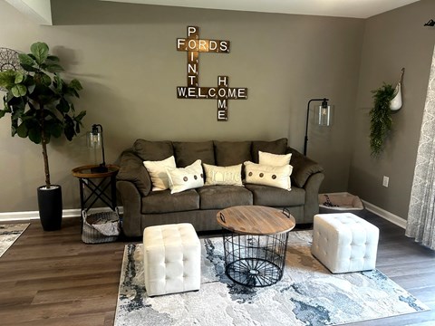 A living room with a brown couch and a rug.