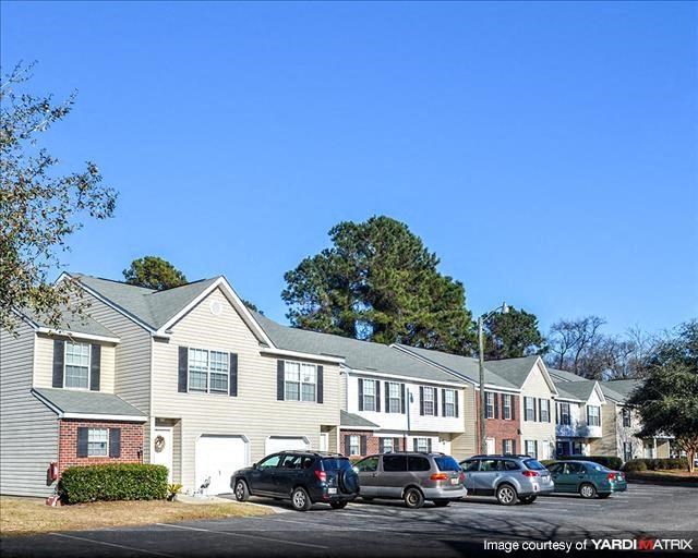 a row of houses with cars parked in front of them