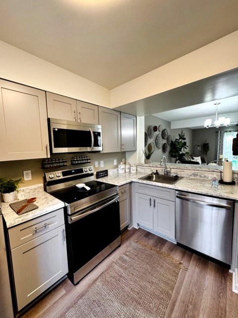 A kitchen with a black stove top oven and white cabinets.