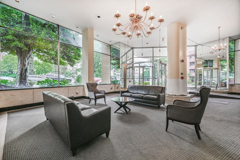 A large room with a chandelier and a view of trees outside the windows.