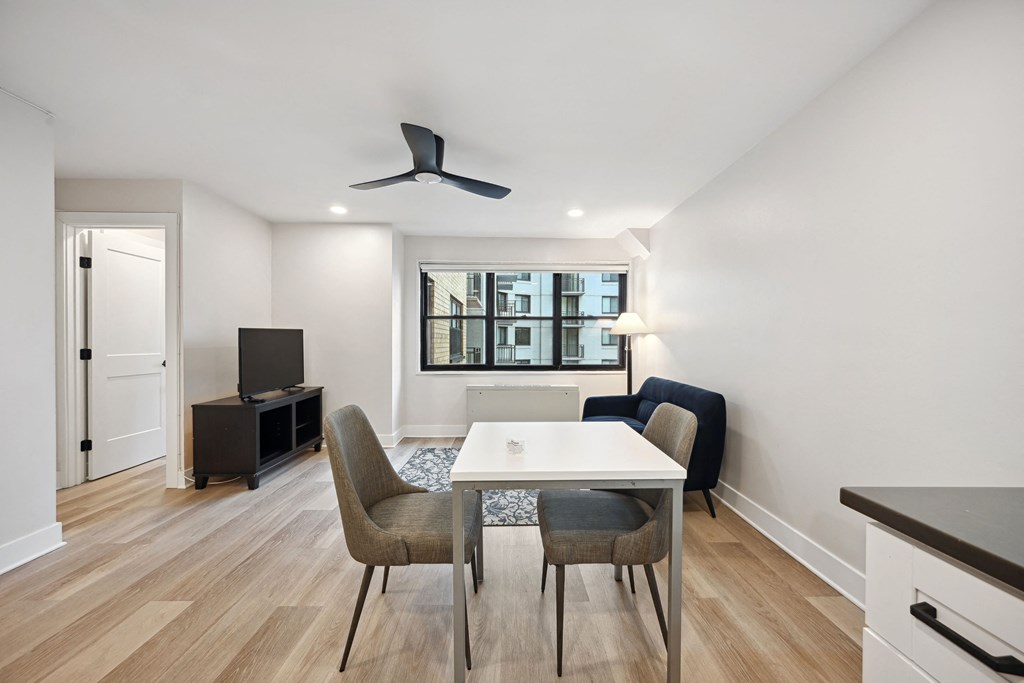 a living room with a white table and chairs and a tv