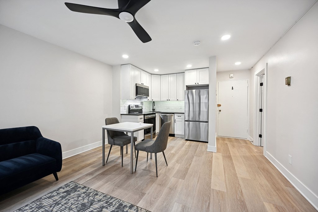 a living room and kitchen with a table and chairs