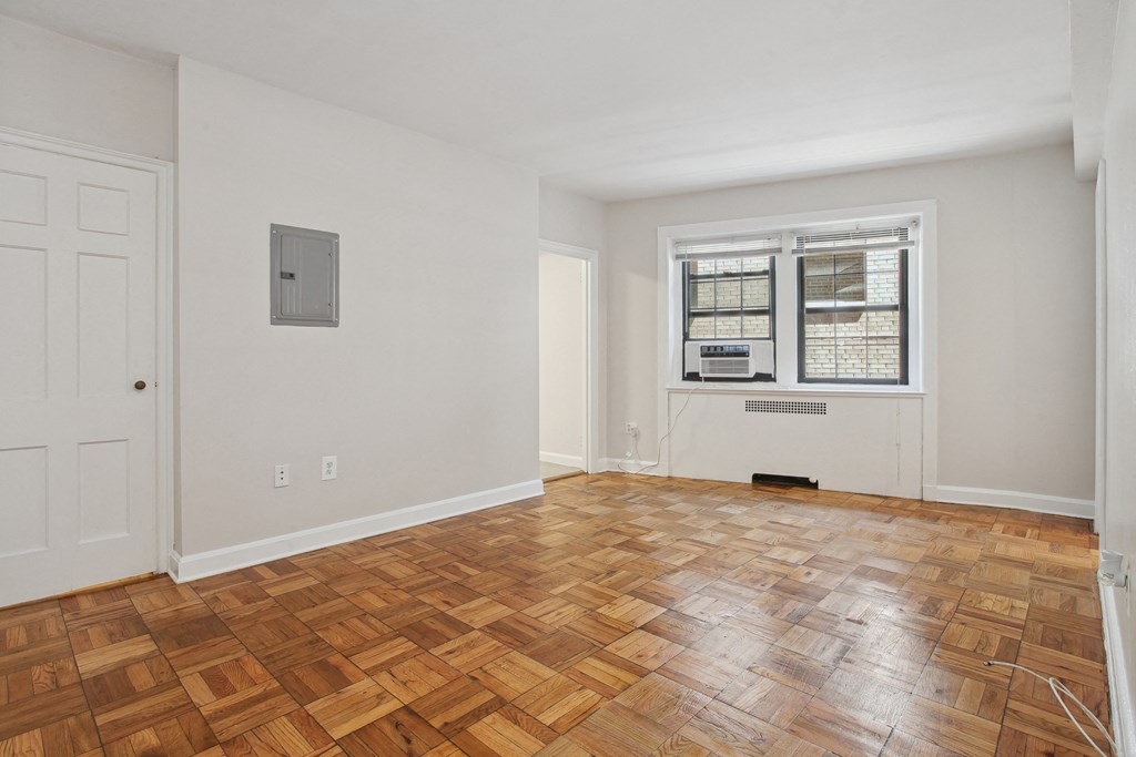 a living room with a hardwood floor and a window