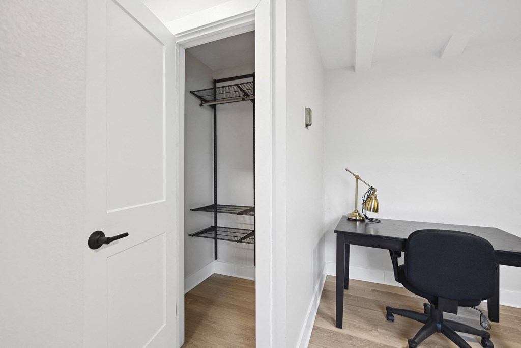 a room with a desk and a chair and a closet