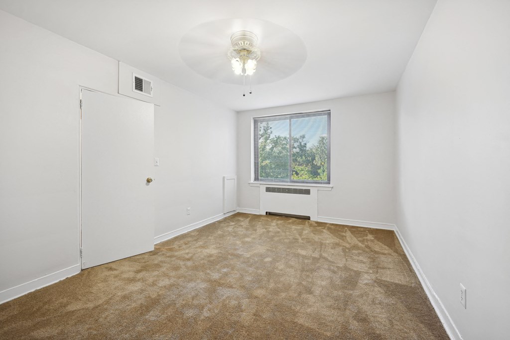 an empty room with carpet and a window