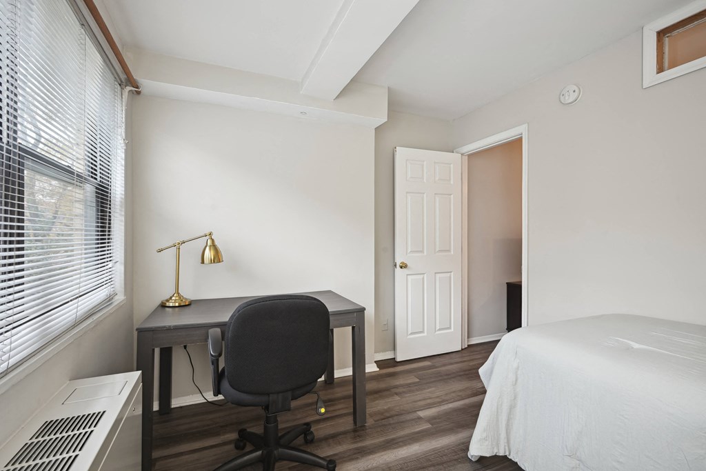 a bedroom with a bed and a desk with a chair