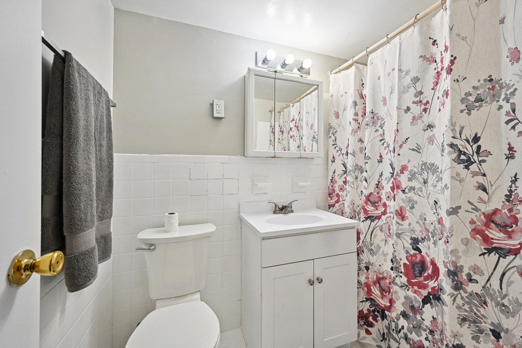 a bathroom with a shower curtain and a toilet and a sink