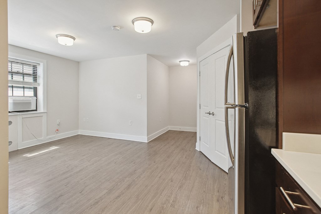 a bedroom with a medium sized bed and a refrigerator in a room