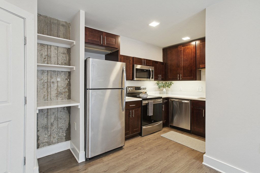 a kitchen with dark wood cabinets and stainless steel appliances
