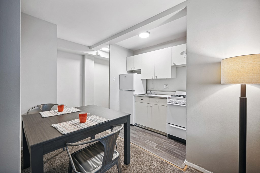 a kitchen and dining room with white appliances and a table and chairs