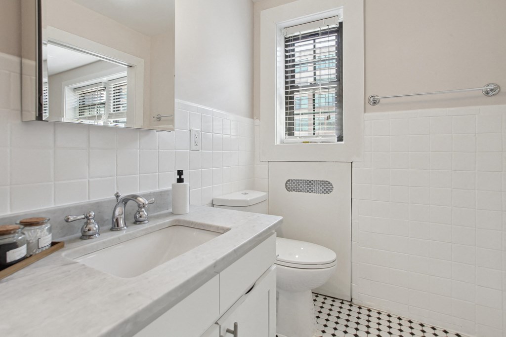 a white bathroom with a black and white checkered floor