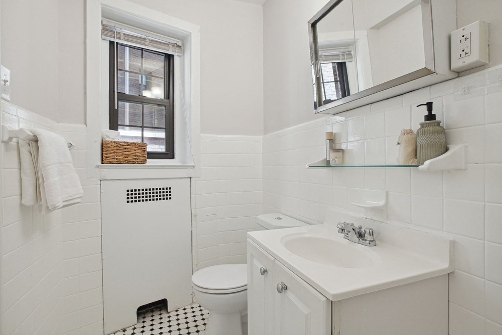a white bathroom with a black and white checkered floor