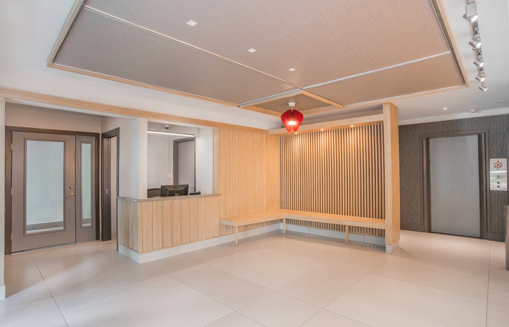 a lobby with a reception desk and a red light on the ceiling