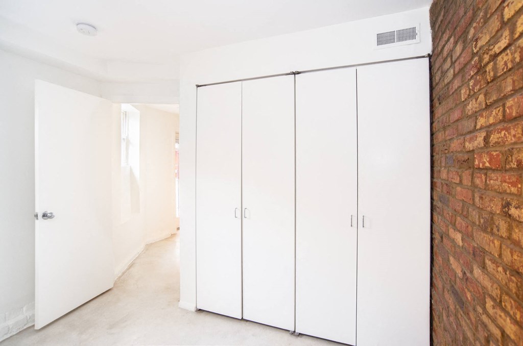 a brick wall in a room with white closets