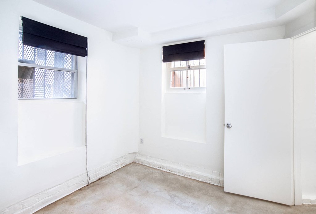 a room with white walls and a window and a door