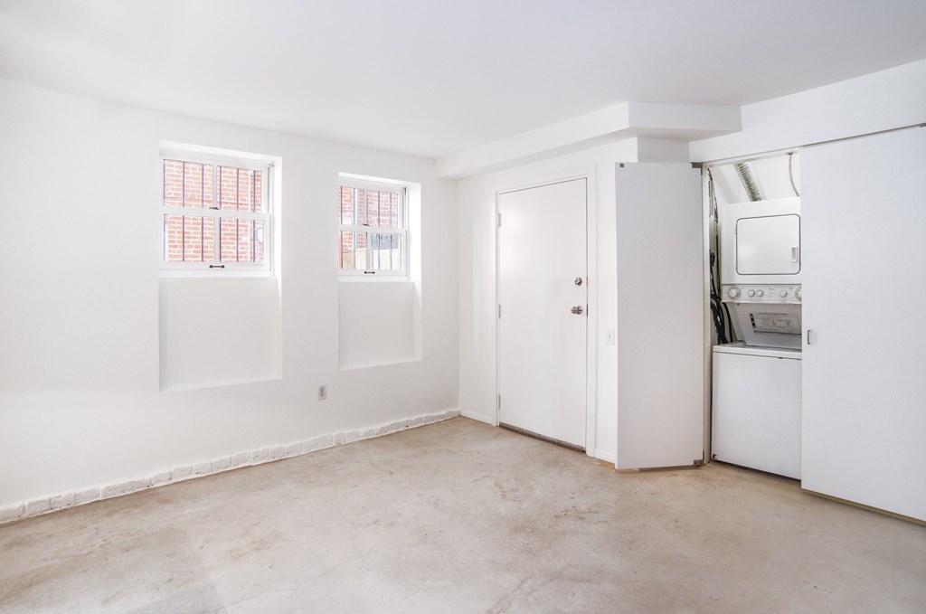 a kitchen with white walls and white appliances and a white door and window