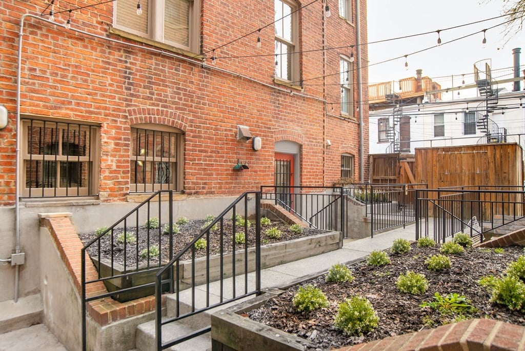the back of a brick building with a garden in front of it
