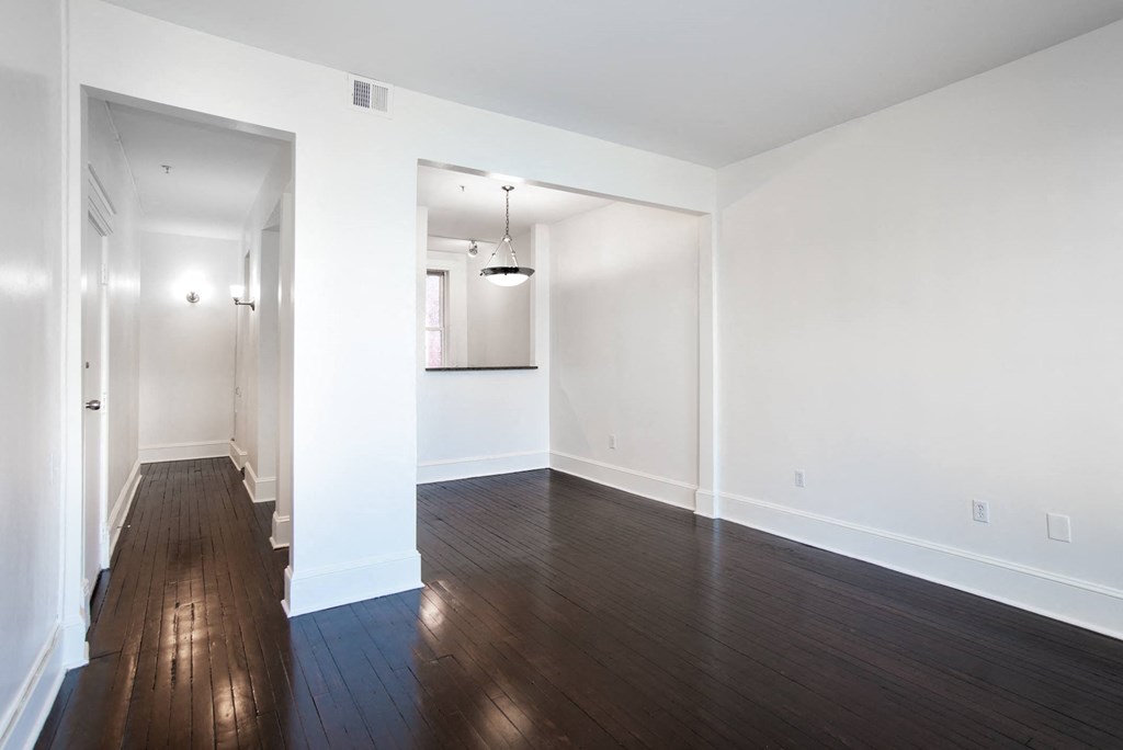 an empty living room with white walls and wood floors