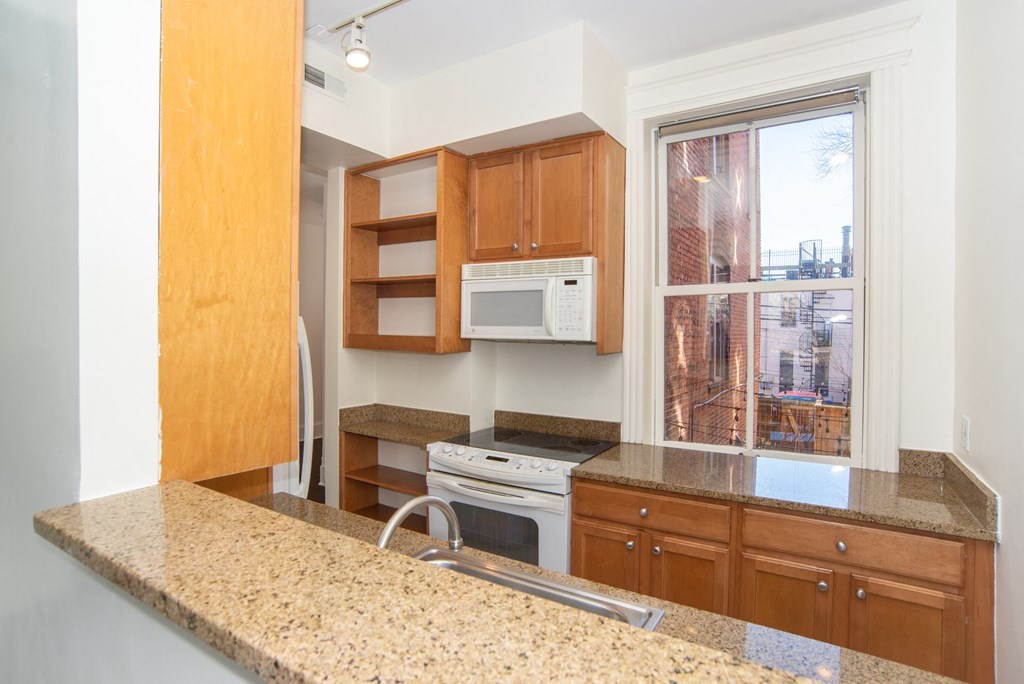 a kitchen with granite counter tops and wooden cabinets