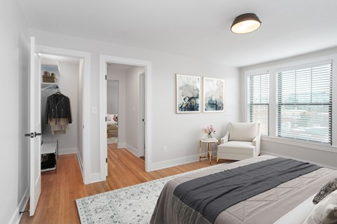 A bedroom with a large bed and a painting on the wall.