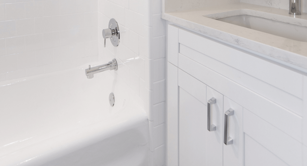 a white bathroom with a tub and a sink