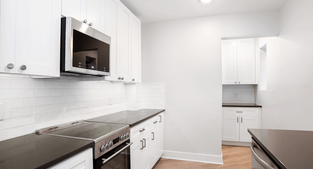 a kitchen with white cabinets and a stove and a microwave