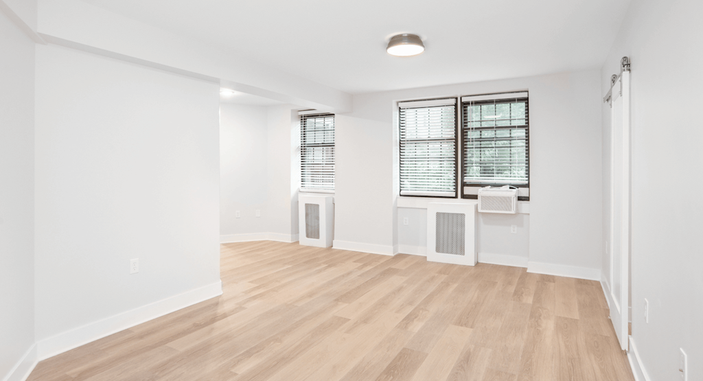 an empty living room with white walls and wood flooring