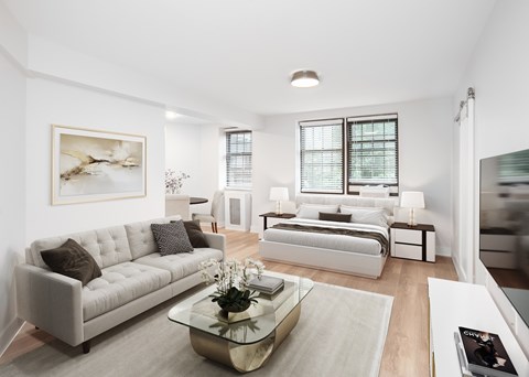 A modern living room with a white couch and a coffee table in the center.