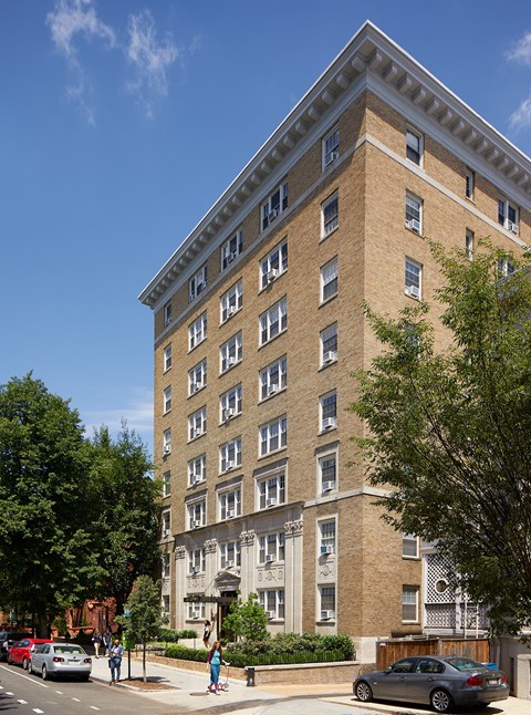 a tall brick building with cars parked in front of it